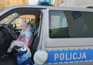 Dziewczynka siedzi w radiowozie