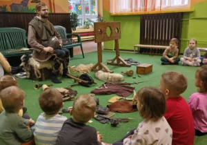 Prowadzący opowiada dzieciom o średniowieczu
