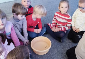 Dzieci wrzucają monety do miski z wodą