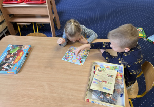 Dzieci grają w grę planszową przy stoliku