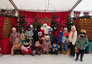 Dzieci pozują do zdjęcia z Mikołajem