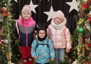 Dzieci pozują do zdjęcia w świątecznej aranżacji