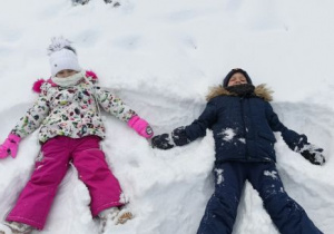 Dzieci robią orzełki na śniegu
