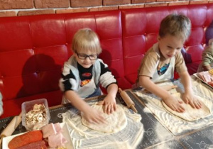 Chłopcy formują placek pizzy