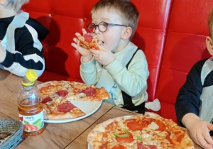Chłopiec je pizze