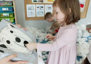 Dziewczynka karmi misia fokami