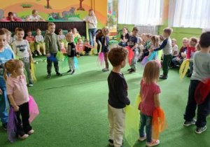 Dzieci tańczą w kole z chusteczkami